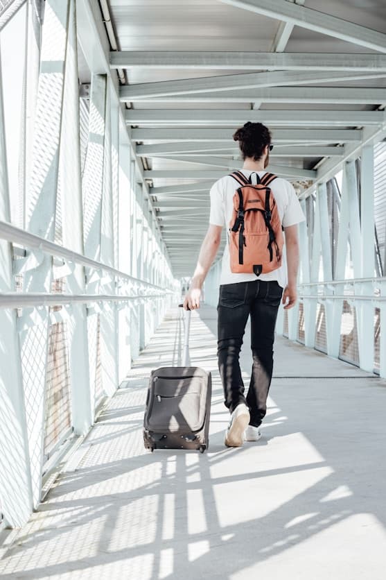 Traveler with backpack walking on boardwalk bridge